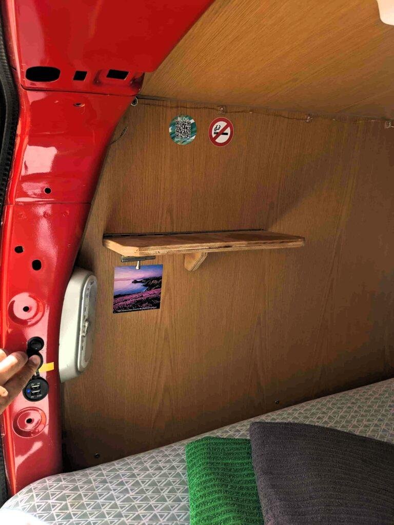 Interior side panel with shelf and lights above the bed