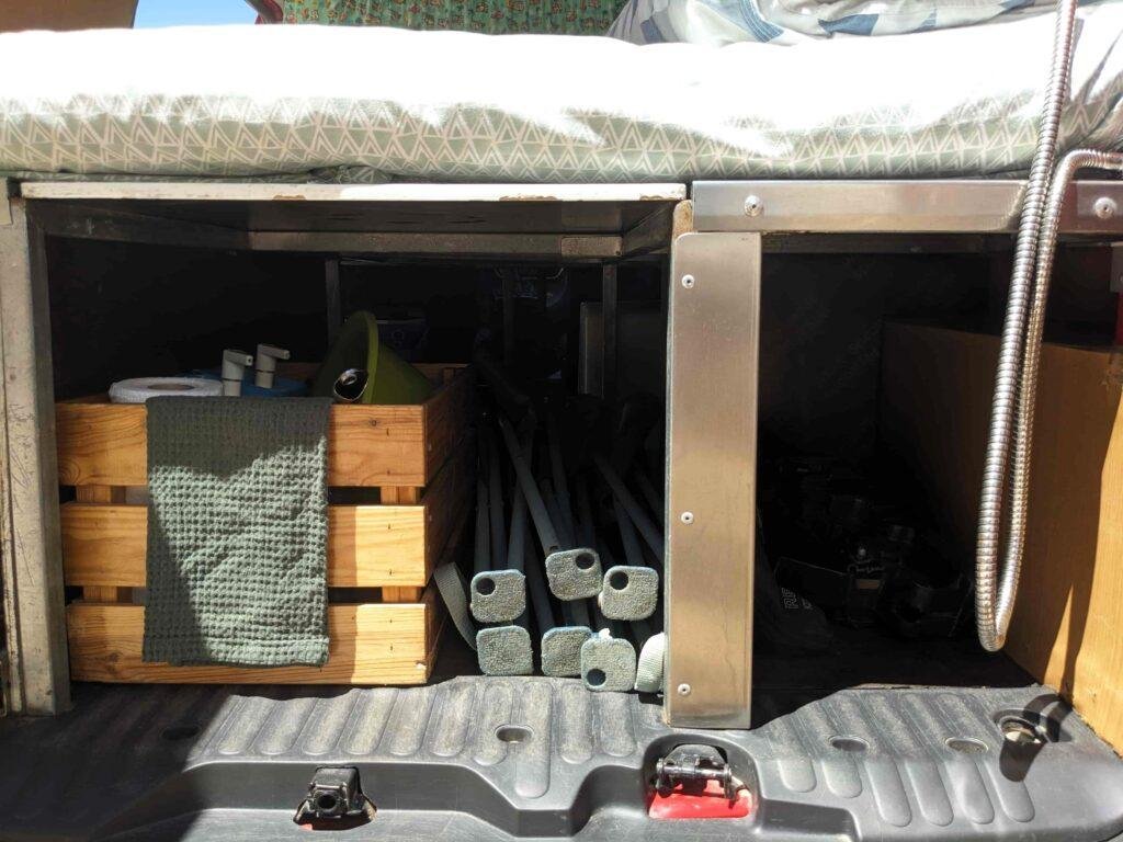 Storage under the bed with water canisters and camping gear