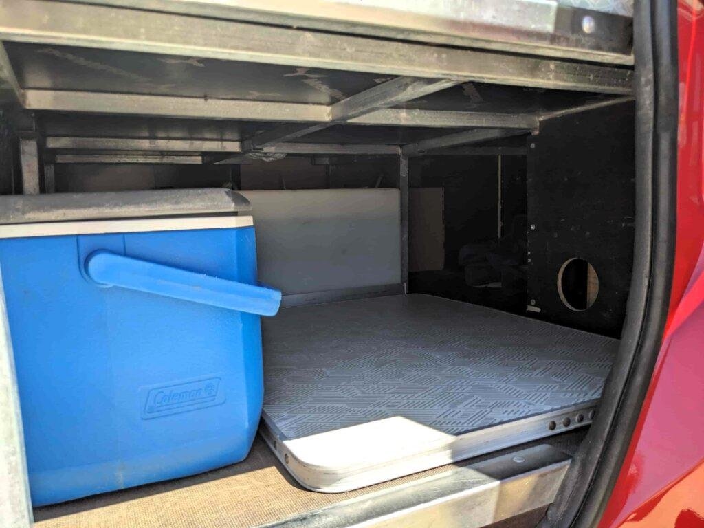 Storage space with cool box under the bed of the mini campervan